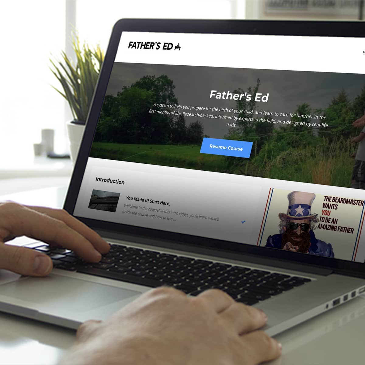 Person using a laptop with 'Father's Ed' website displayed on the screen.