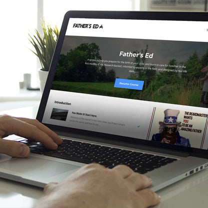 Person using a laptop with 'Father's Ed' website displayed on the screen.